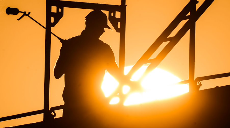 Ein Handwerker mit einem Gasbrenner beim Bau eines Mehrfamilienhauses. / Foto: Julian Stratenschulte/dpa/Symbolbild