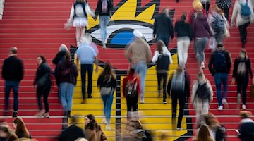 Visitors walk down a staircase with the logo of the Leipzig Book Fair at the beginning of the fair day... / Photo: Hendrik Schmidt/dpa/archive image
