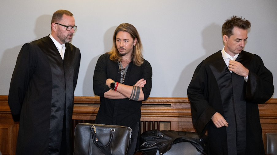 Gil Ofarim (M) steht im Saal des Landgerichts in Leipzig zwischen seinen Anwälten. / Foto: Hendrik Schmidt/dpa