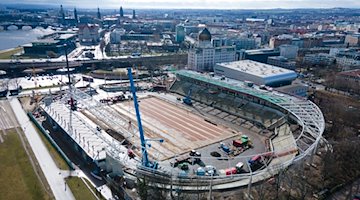Два крани піднімають легку кільцеву опору над північною трибуною стадіону в Дрездені / Фото: Sebastian Kahnert/dpa