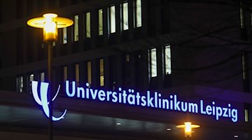 Der Schriftzug der Uniklinik Leipzig leuchtet über dem Eingang. / Foto: Jan Woitas/dpa-Zentralbild/dpa