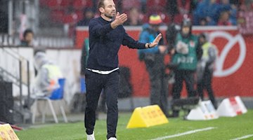 Im strömenden Regen dirigiert der Mainzer Interimstrainer Jan Siewert sein Team. / Foto: Jürgen Kessler/dpa