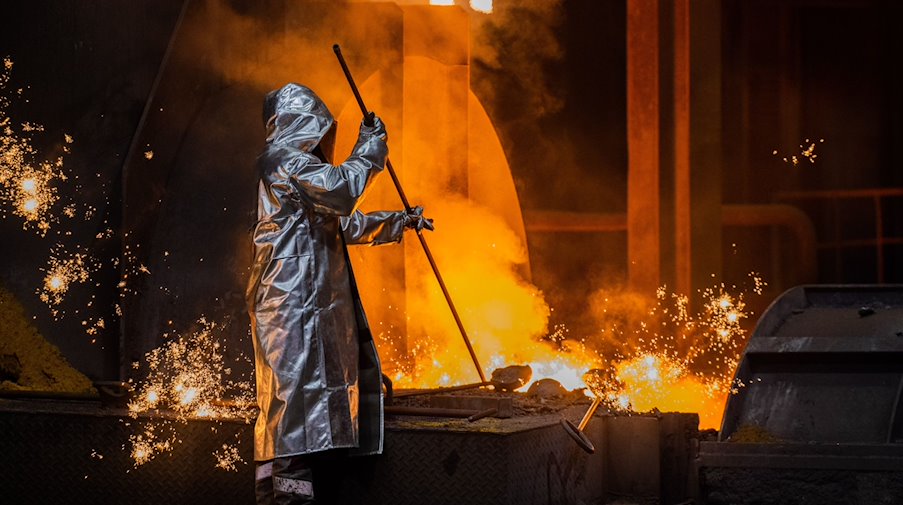 Ein Stahlarbeiter von Thyssenkrupp prüft den Roheisen am Hochofen 8 auf dem Werksgelände. / Foto: Rolf Vennenbernd/dpa/Archivbild
