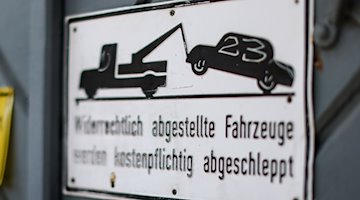 Ein Schild weist darauf hin, dass widerrechtlich abgestellte Fahrzeuge abgeschleppt werden. / Foto: Jan Woitas/dpa
