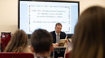 Michael Kretschmer (CDU), Ministerpräsident von Sachsen, liest im Rahmen des bundesweiten Vorlesetages Grundschülern vor. / Foto: Robert Michael/dpa