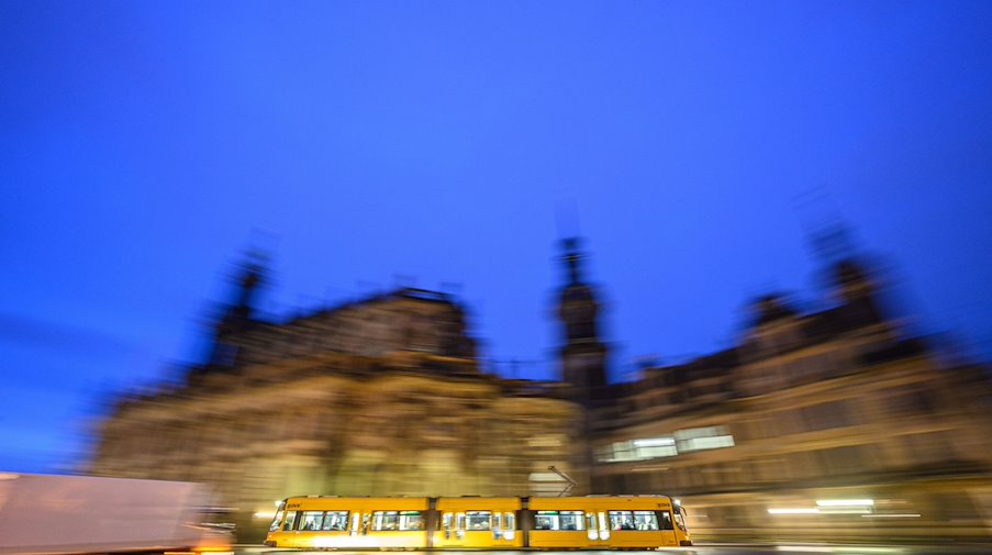 Eine Straßenbahn der Dresdner Verkehrsbetriebe (DVB) fährt am Morgen in der Altstadt vor der Hofkirche. / Foto: Robert Michael/dpa
