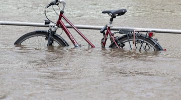 Das Hochwasser der Elbe umgibt ein Fahrrad am Terrassenufer. / Foto: Sebastian Kahnert/dpa
