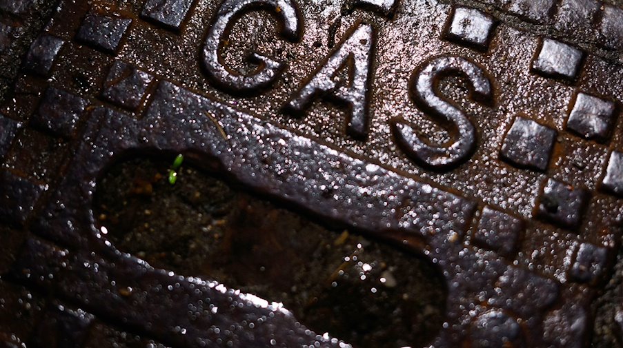 Ein Schriftzug „Gas“ steht auf einer gusseisernen Straßenkappe einer Gasleitung. / Foto: Julian Stratenschulte/dpa/Symbolbild