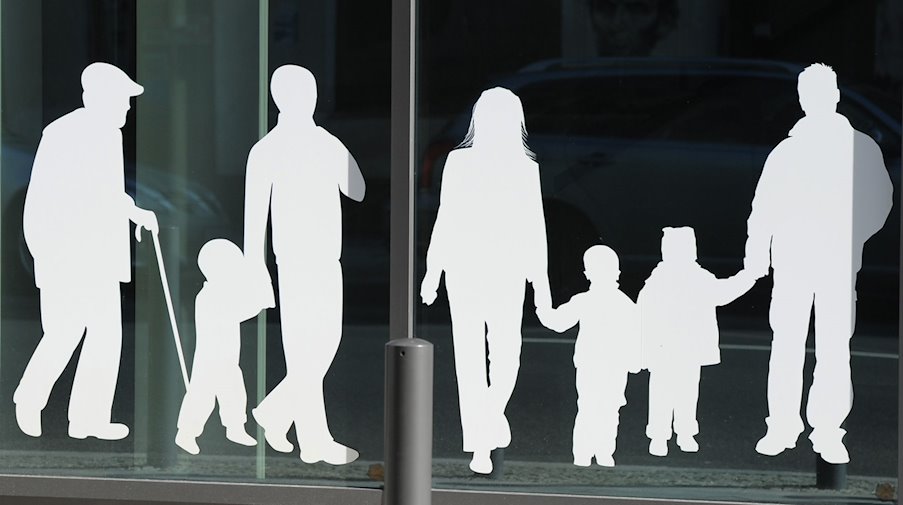 Figuren von Menschen in verschiedenem Alter sind auf Fensterscheiben aufgeklebt. / Foto: Jens Kalaene/dpa-Zentralbild/dpa