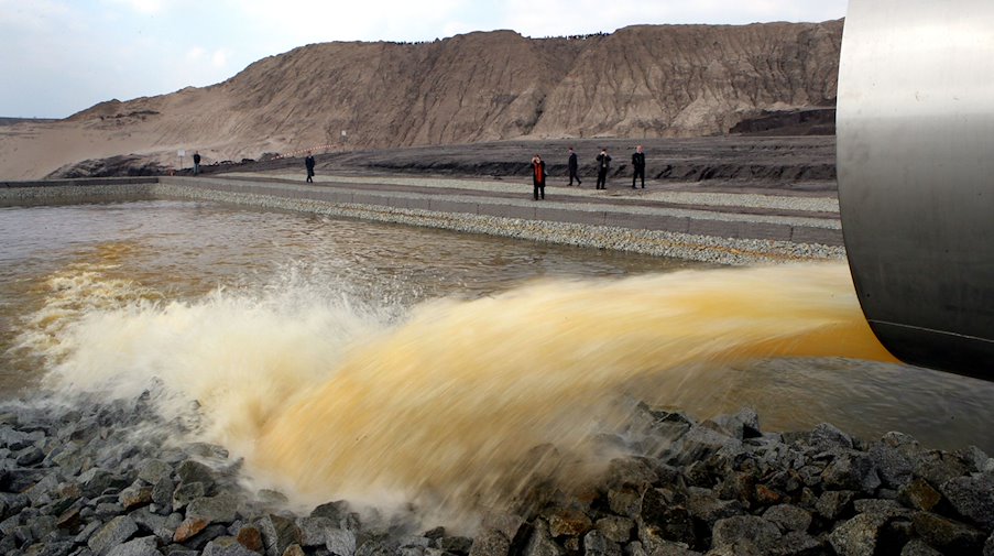 Water flows out of a flooding pipe into a former open-cast mine / Photo: Patrick Pleul/dpa-Zentralbild/dpa