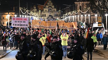 مشاركون في تظاهرة لحركة Pegida المتطرفة اليمينية يمشون عبر جسر أوغستوس. / صورة: روبرت مايكل / وكالة الأنباء الألمانية