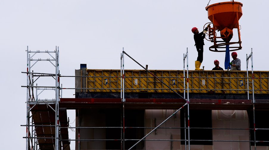 عمّال يقفون في موقع بناء لمبنى سكني. / الصورة: سورين شتاخي / وكالة الأنباء الألمانية / صورة رمزية
