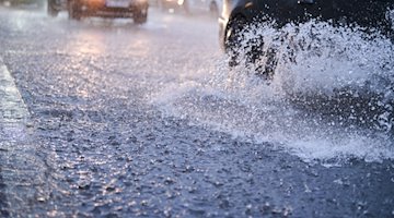 Autos fahren bei starkem Regen durch tiefe Pfützen. / Foto: Annette Riedl/dpa/Symbolbild