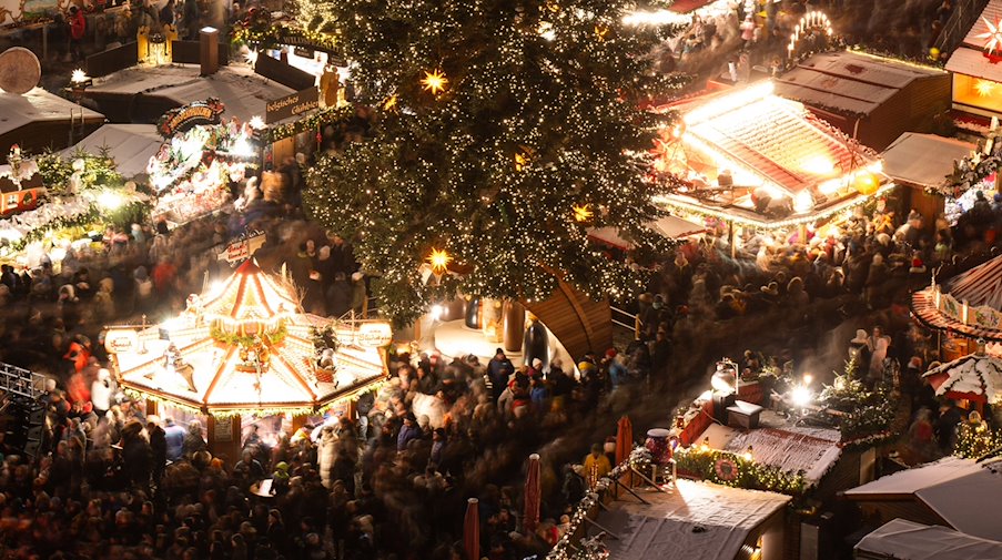 The stalls at the 589th Dresden Striezelmarkt are brightly lit for the opening / Photo: Sebastian Kahnert/dpa