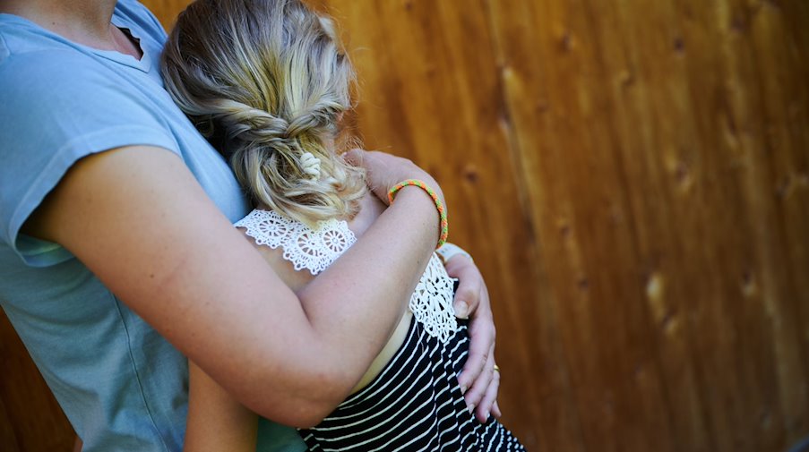 Ein Mädchen wird von seiner Mutter in den Arm genommen und getröstet. / Foto: Annette Riedl/dpa/Symbolbild