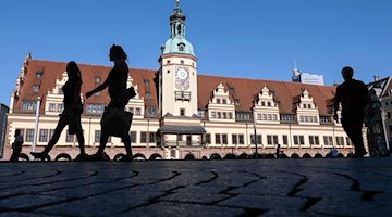 Passers-by walk past the Old Town Hall in Leipzig's city center. The historic building has been home to the City History Museum since 1909 / Photo: Jens Kalaene/dpa-Zentralbild/ZB