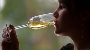 Eine Frau trinkt Sekt. / Foto: Matthias Rietschel/dpa/Symbolbild
