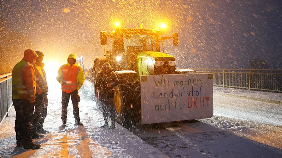 Los agricultores protestan con sus tractores y carteles en un puente sobre la autopista A23 / Foto: Marcus Brandt/dpa
