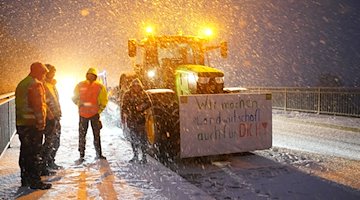 Bauern protestieren mit ihren Traktoren und Plakaten auf einer Brücke über der Autobahn A23. / Foto: Marcus Brandt/dpa