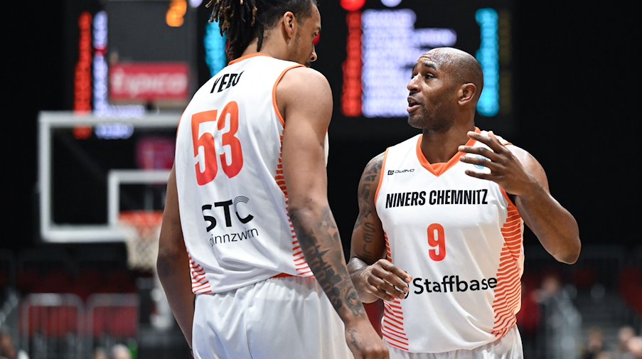 Kevin Yebo (i) y DeAndre Lansdowne, del Chemnitz, conversan sobre el terreno de juego / Foto: Hendrik Schmidt/dpa/Archivbild