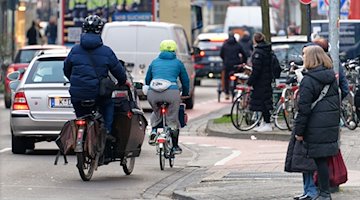Автомобілі, велосипедисти та пішоходи на дорозі / Фото: Henning Kaiser/dpa