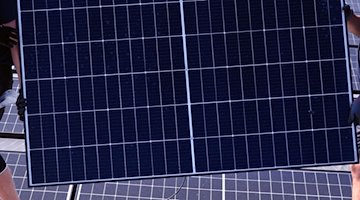 Монтажники несуть сонячний модуль на дах / Фото: Waltraud Grubitzsch/dpa/Archivbild