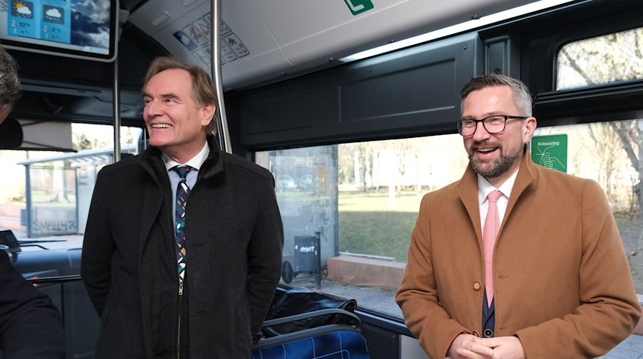 Burkhard Jung (SPD, l), Leipzigs Oberbürgermeister, und Martin Dulig (SPD), Wirtschaftsminister des Landes Sachsen, stehen in einem E-Bus. / Foto: Sebastian Willnow/dpa