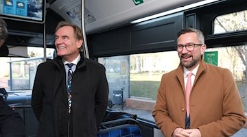 Буркхард Юнг (СДПН, ліворуч), мер Лейпцига, і Мартін Дуліг (СДПН), міністр економіки Саксонії, стоять в електронному автобусі / Фото: Sebastian Willnow/dpa