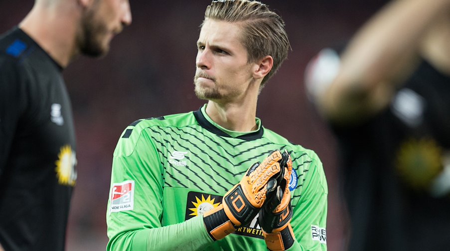 Duisburg goalkeeper Daniel Mesenhöler stands on the pitch and claps / Photo: Annegret Hilse/dpa