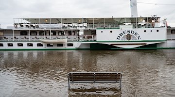 A bench on the terrace bank in front of the historic paddle steamer is washed over by the Elbe flood / Photo: Robert Michael/dpa