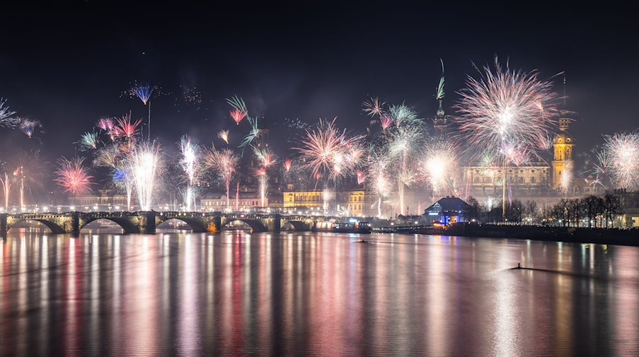 Feuerwerk explodiert in der Silvesternacht über der histoischen Altstadtkulisse an der Elbe. / Foto: Robert Michael/dpa