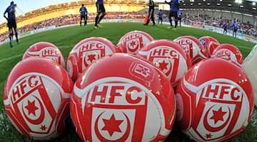 Balones con el logotipo del Hallescher FC sobre el terreno de juego / Foto: Hendrik Schmidt/dpa-Zentralbild/dpa