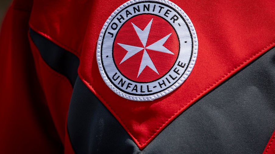 Das Logo der Johanniter-Unfall-Hilfe ist auf der Jacke eines Pressesprechers zu sehen. / Foto: Moritz Frankenberg/dpa
