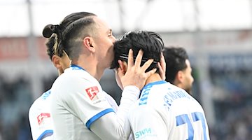 Гравець "Магдебурга" Баріс Атік (ліворуч) цілує Тацую Іто в голову після перемоги з рахунком 1:0 / Фото: Sebastian Christoph Gollnow/dpa