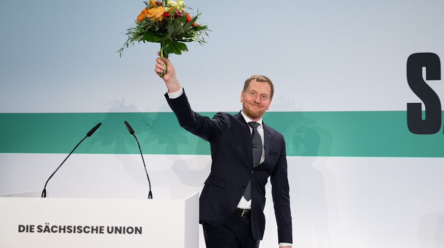 Michael Kretschmer (CDU), Minister President of Saxony, holds a bouquet of flowers after his election to first place on the list for the state parliamentary elections at the CDU Saxony state representatives' meeting. / Photo: Sebastian Kahnert/dpa
