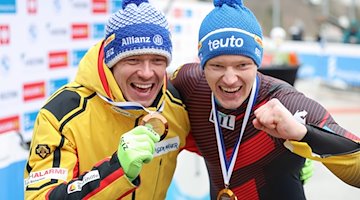 Max Langenhan (l, Platz eins) und Felix Loch (r, Platz drei), beide aus Deutschland, stehen nach einer Siegerehrung zusammen. / Foto: Friso Gentsch/dpa