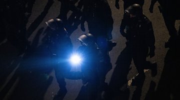 شرطيون يرافقون مظاهرة لحركة بيجيدا المتطرفة اليمينية وينيرانها بكشاف. / صورة: روبرت مايكل / dpa / صورة أرشيفية