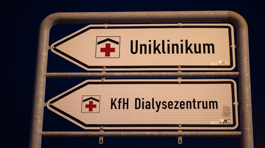 Wegweiser mit der Aufschrift Uniklinikum und KfH Dialysezentrum sind im Dresdner Stadtteil Johannstadt montiert. / Foto: Robert Michael/dpa