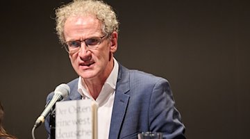 Dirk Oschmann, escritor y literato, habla en el escenario / Foto: Annette Riedl/dpa