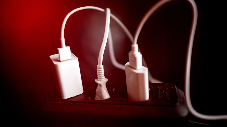 A power strip with cables, plugs and chargers. / Photo: Sina Schuldt/dpa/symbol image