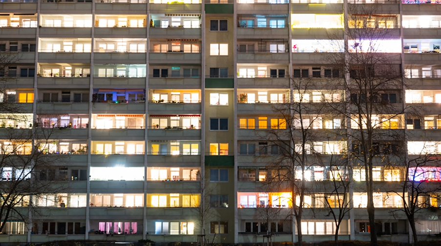In einem Hochhaus sind einige Fenster beleuchtet. / Foto: Christophe Gateau/dpa
