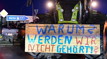 Ein Protestschild an einem Traktor. / Foto: Heiko Rebsch/dpa