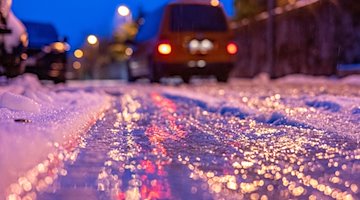 Eine dünne Eisschicht überzieht am frühen Morgen eine Straße. / Foto: Armin Weigel/dpa/Symbolbild