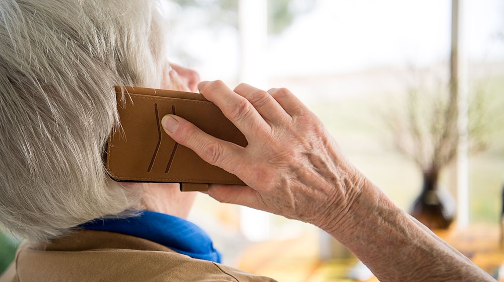 Eine Seniorin telefoniert mit ihrem Smartphone. / Foto: Sebastian Gollnow/dpa