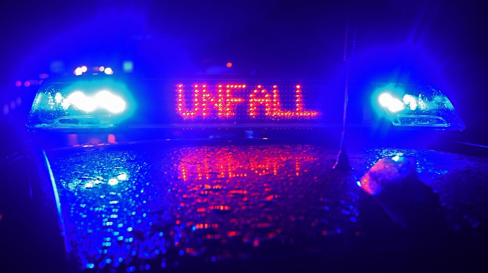 "Unfall" in roten LED-Leuchtbuchstaben steht zwischen zwei Blaulichtern auf dem Dach eines Polizeiwagens. / Foto: Stefan Puchner/dpa/Archivbild