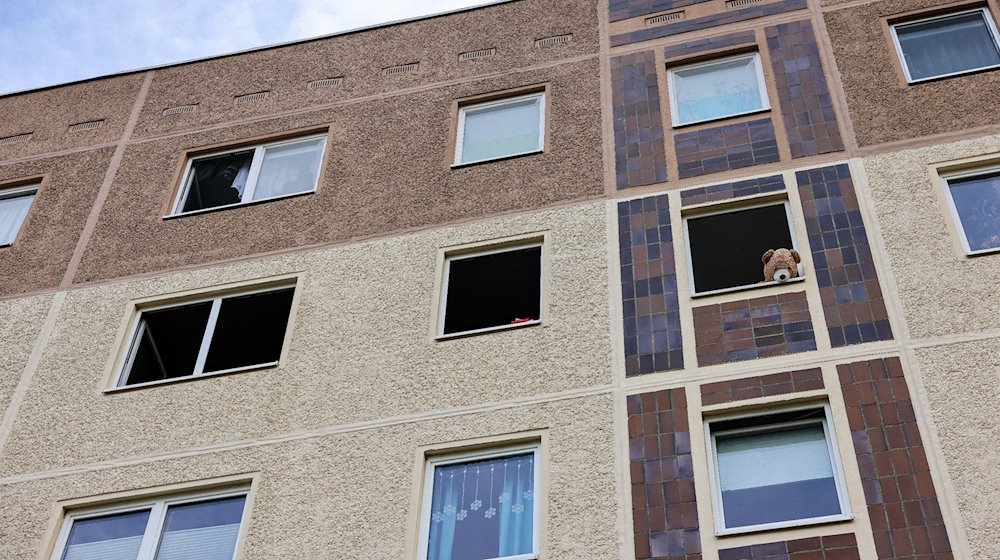 Mit einem Teddybären ist nach einem Brand ein geöffnetes Fenster einer Wohnung im Leipziger Stadtteil Paunsdorf blockiert. / Foto: Jan Woitas/dpa