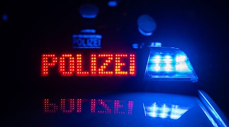 Zwei Polizisten vor einem Polizeifahrzeug. / Foto: Marijan Murat/dpa/Symbolbild