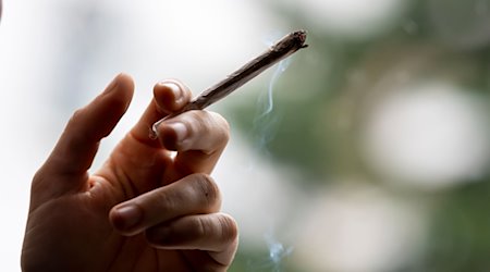 Eine Person raucht einen Joint. Die Ampel-Parteien wollen Cannabis mit genauen Regeln legalisieren. / Foto: Fabian Sommer/dpa/Archivbild