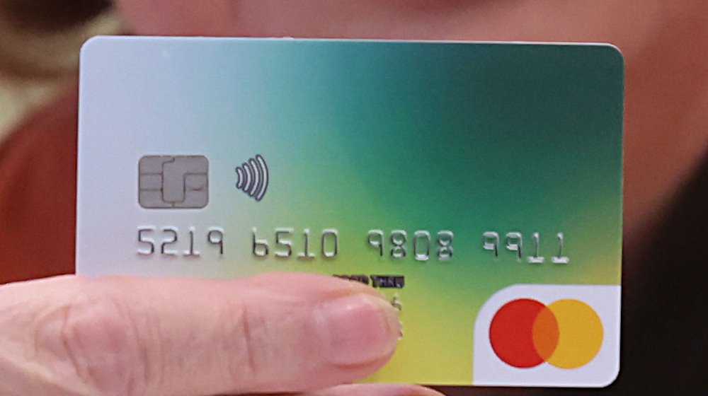 Платіжну картку демонструють на прес-конференції в районній адміністрації. З 1 грудня 2023 року в окрузі Грайц (Тюрінгія) видається платіжна картка для шукачів притулку. / Фото: Bodo Schackow/dpa