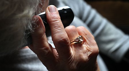 Eine ältere Frau telefoniert mit einem schnurlosen Festnetztelefon. / Foto: Karl-Josef Hildenbrand/dpa